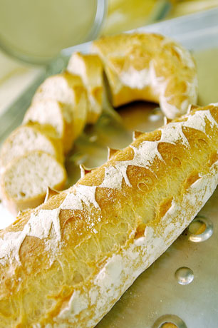 Filone di pane artigianale. Croccante, dorato e tagliato a fette. Pane fresco.