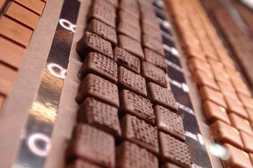 File di cioccolatini assortiti. Praline artigianali al cioccolato al latte e fondente.
