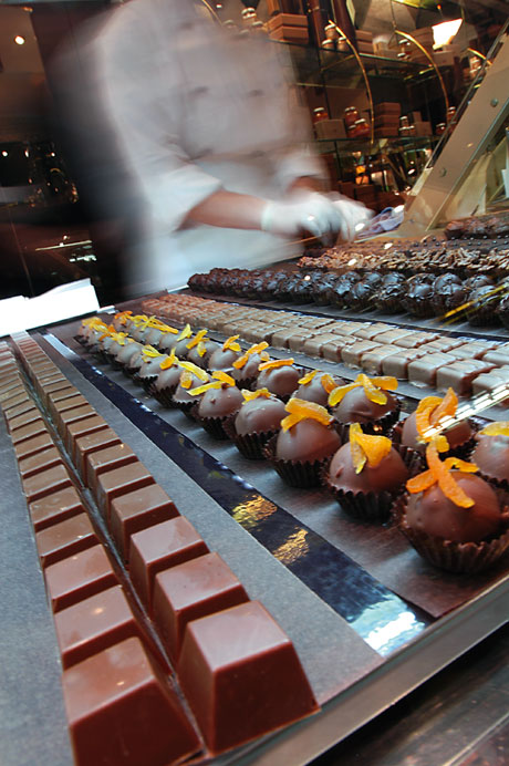 Assortimento di praline artigianali al cioccolato. Dolci cioccolatini gourmet con decorazioni di arancia candita. Pasticceria di lusso.