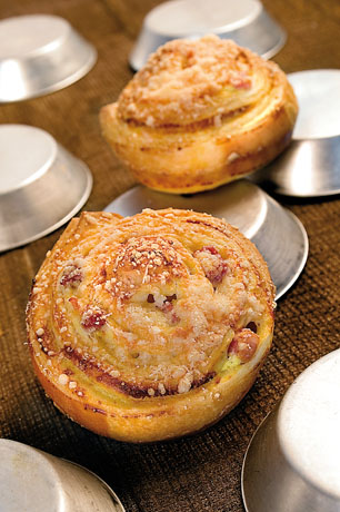 Rotoli golosi con prosciutto e formaggio. Pasticceria salata artigianale, ideale per un brunch o aperitivo sfizioso.