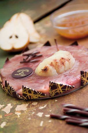 Tarte Tatin alle Pere: torta rotonda con pere caramellate, decorazioni di cioccolato e salsa. Dessert delizioso.