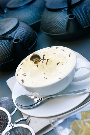 Tazza di tè freddo con ghiaccio e teiere in ghisa. Bevanda rinfrescante.