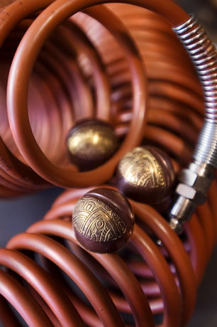 Cioccolatini artigianali decorati su tubo arancione. Praline al cioccolato fondente con decorazioni dorate. Dolci prelibatezze.