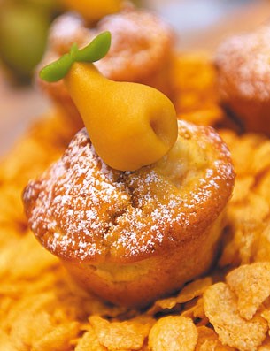 Muffin con pera di marzapane e zucchero a velo. Dolci fatti in casa, pasticceria artigianale.