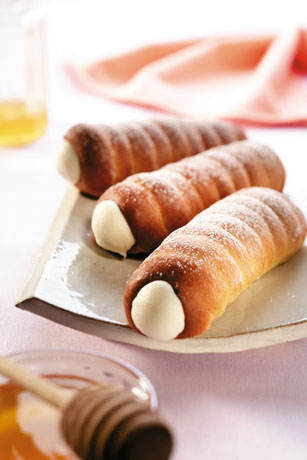 Cannoli siciliani al miele su piatto. Dessert tradizionale italiano con ricotta dolce. Pasticceria artigianale.