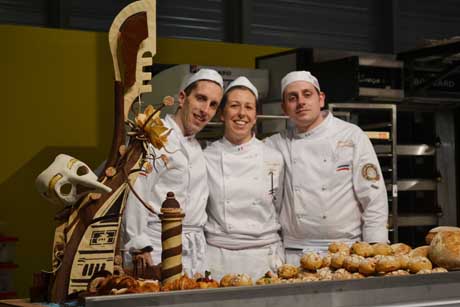 Tre chef pasticceri con scultura di cioccolato a tema Venezia. Dolci artigianali, pasticceria italiana.
