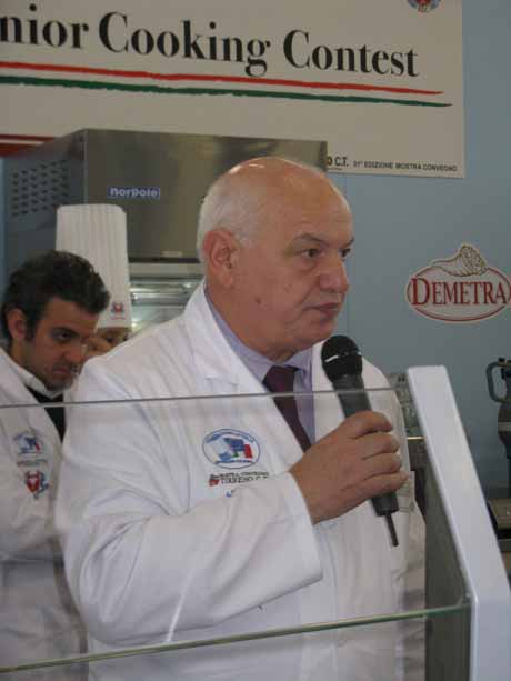 Uomo con microfono a concorso di cucina. Chef in giuria a evento gastronomico.