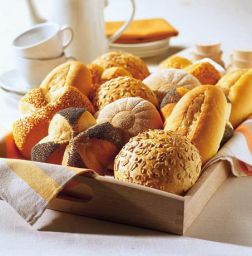 Assortimento di pane fresco su vassoio. Panini misti con semi, papavero e sesamo. Ottimi per colazione.