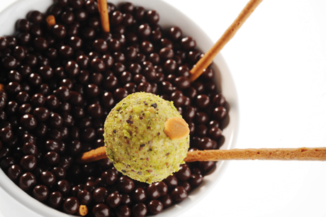 Dolciumi: palline di cioccolato, tartufo al pistacchio su bastoncino. Delizie artigianali.