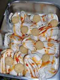 Gelato artigianale in vaschetta con amaretti e salsa. Dessert fresco e goloso.