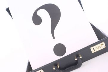 Punto interrogativo su valigetta. Dubbio, affari, incertezza, soluzione.