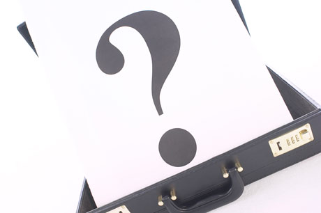 Punto interrogativo su valigetta. Dubbio, affari, incertezza, soluzione.