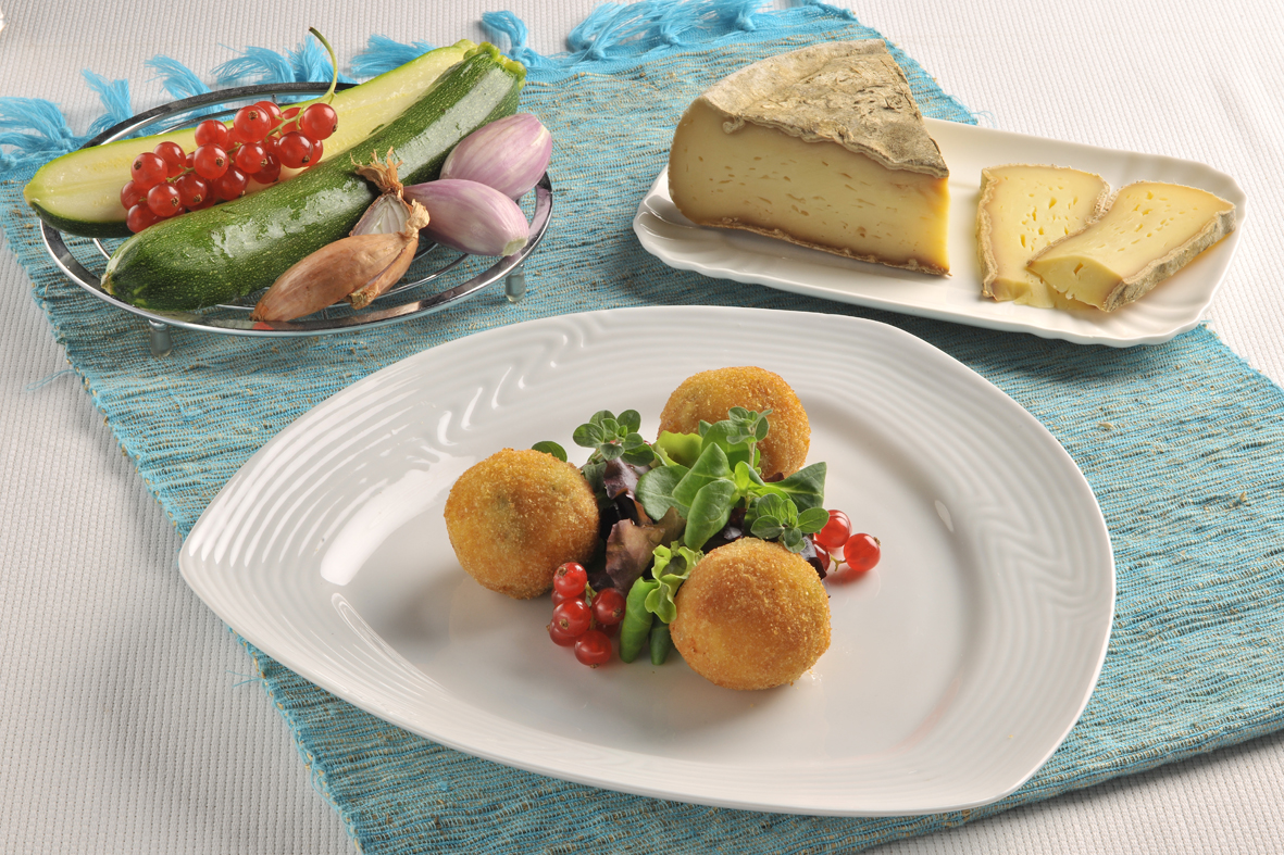 Arancini di riso con verdure e Tomme de Savoie. Piatto gourmet, cucina italiana.