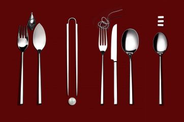 Set di posate Marchesi su sfondo bordeaux. Design moderno con forchetta, coltello, cucchiaio e accessori tavola.