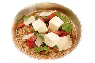 Gelato gourmet nel piatto: cubetti di gelato, prosciutto crudo, scaglie di formaggio e rucola.