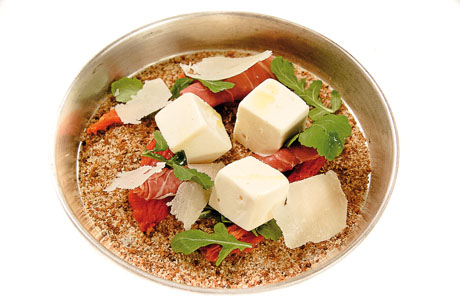 Gelato gourmet nel piatto: cubetti di gelato, prosciutto crudo, scaglie di formaggio e rucola.