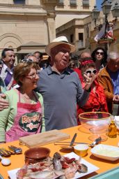 Mengacci in piazza cucina ricette di famiglia. Tavolo con pesce fresco, olio e utensili. Evento culinario all'aperto.