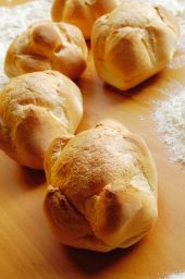 Michetta fresca su tavolo di legno. Pane tipico milanese, croccante e fragrante. Panino vuoto.