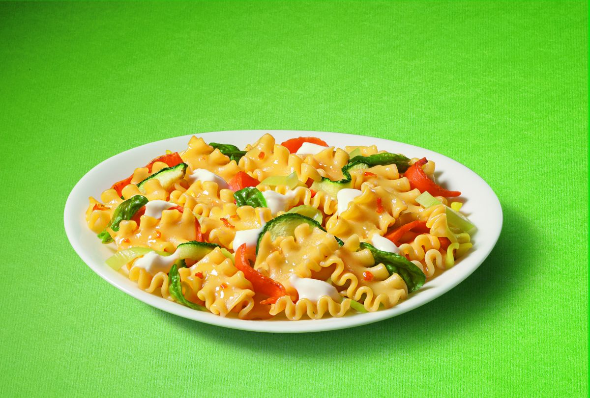 Piatto di mafalde corte con verdure fresche. Pasta italiana, zucchine, peperoni rossi e basilico. Ricetta vegetariana.