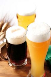 Tre bicchieri di birra artigianale: chiara, scura e ambrata. Schiuma bianca e spessa. Degustazione birre miste.