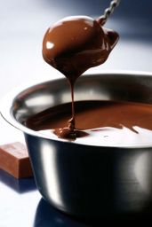 Cioccolato fuso in ciotola. Cucchiaio con cioccolato che cola. Dolce al cioccolato, dessert goloso.