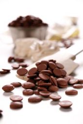Gocce di cioccolato fondente su spatola. Ingredienti per dolci e dessert al cioccolato.