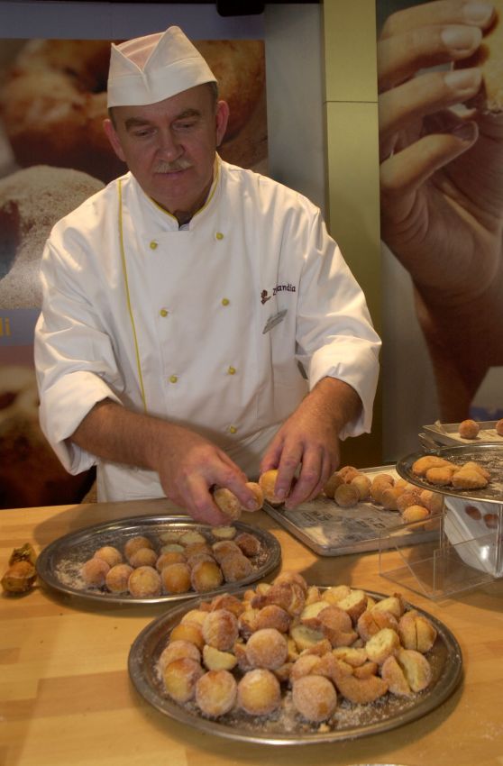 Chef prepara bomboloni. Pasticceria artigianale, dolci fritti, panificazione italiana.