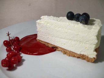 Cheesecake con salsa di fragole e mirtilli. Dessert cremoso e invitante.