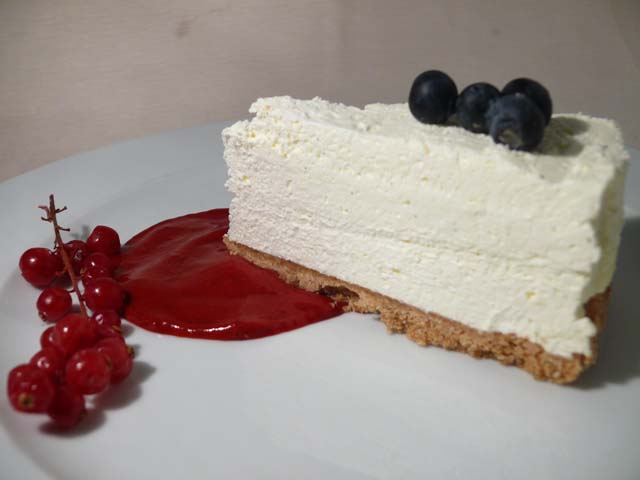 Cheesecake con salsa di fragole e mirtilli. Dessert cremoso e invitante.