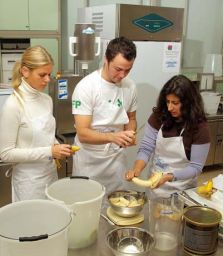 Persone preparano gelato artigianale con banane. Attrezzature Carpigiani in cucina professionale.