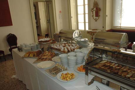 Buffet colazione in sala elegante. Dolci, torte, frutta e scaldavivande in acciaio. Catering per eventi.