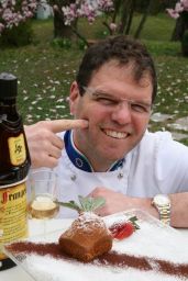 Chef Carlo con torta alle nocciole. Dolce tipico italiano, dessert gourmet con Frangelico.