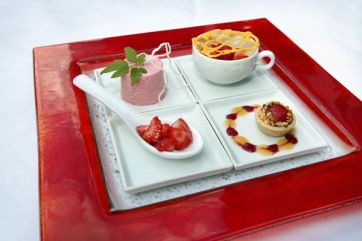 Assortimento di dolci con fragole. Mini torta, mousse e frutta fresca su piatto rosso. #dolci #fragole #dessert