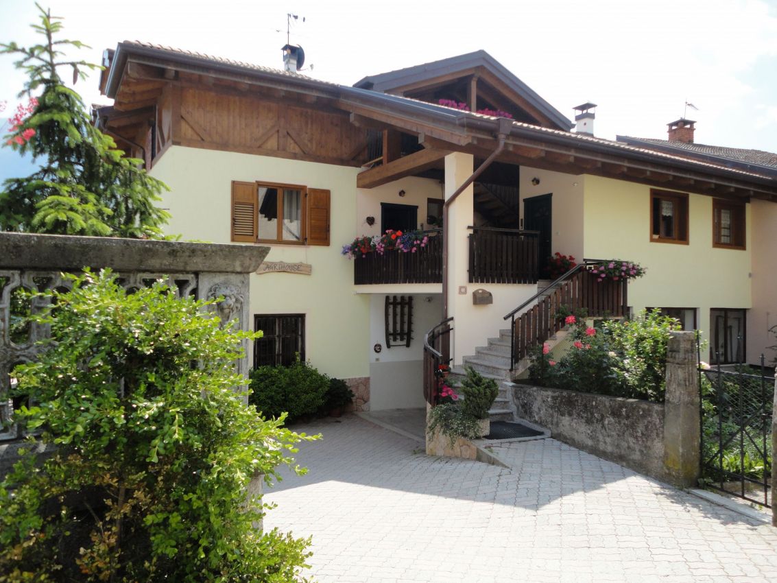 Agriturismo tipico. Casa vacanze con balcone fiorito, scala esterna e dettagli in legno. Ospitalità rurale.