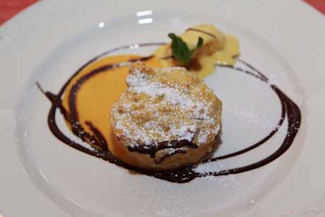 Soufflé di panettone con sorbetto all'arancia. Dessert gourmet con cioccolato e menta.