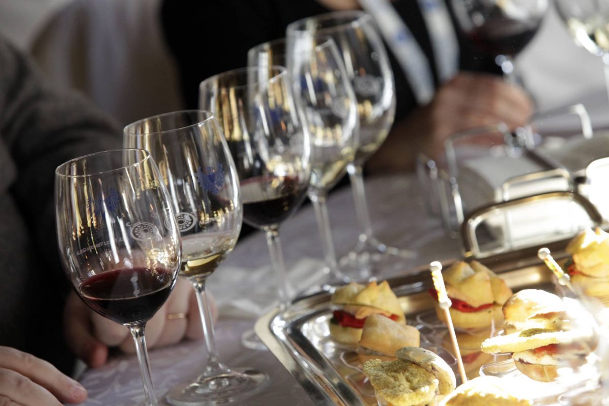 Degustazione vini: calici di vino rosso e bianco con stuzzichini gourmet. Esperienza enogastronomica.