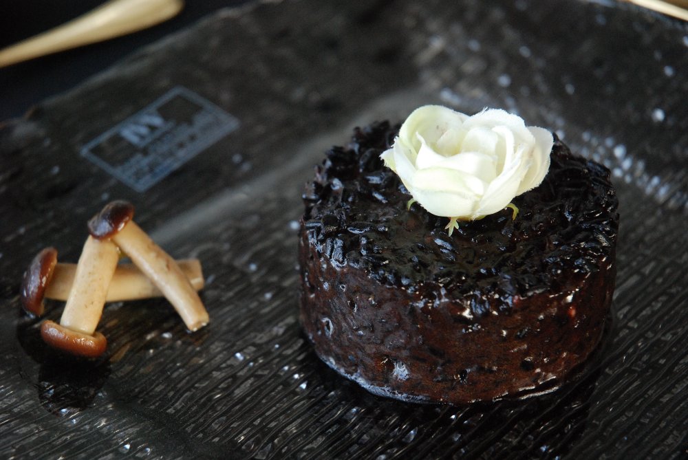 Riso Venere con funghi e fiore. Piatto gourmet, cucina italiana.