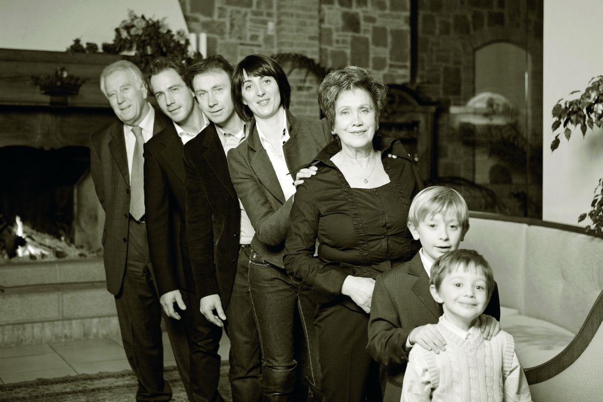 Ritratto di famiglia in bianco e nero. Diverse generazioni, uomini, donne e bambini sorridenti. Ricordo di famiglia.