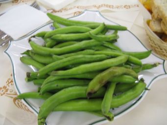 Fave fresche su piatto. Ricetta tradizionale italiana, contorno primaverile, cucina regionale.