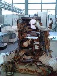 Scultura di pane artistica a tema Australia con uomo, chitarra e cacatua. Sigep Bread Cup.