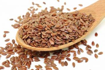 Semi di lino in cucchiaio di legno. Alimento ricco di fibre e omega-3.