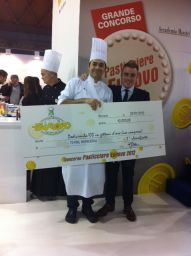 Chef premiato al concorso Pasticciere Eurovo con assegno da 12.000 euro. Vincitore, pasticceria, evento gastronomico.