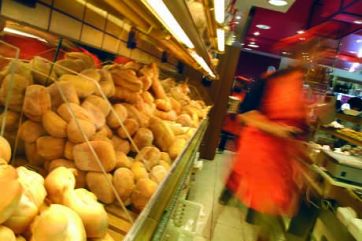 Pane fresco in panificio. Scaffale pieno di pane artigianale, ideale per colazione o pranzo. Guadagnare con prodotti da forno.
