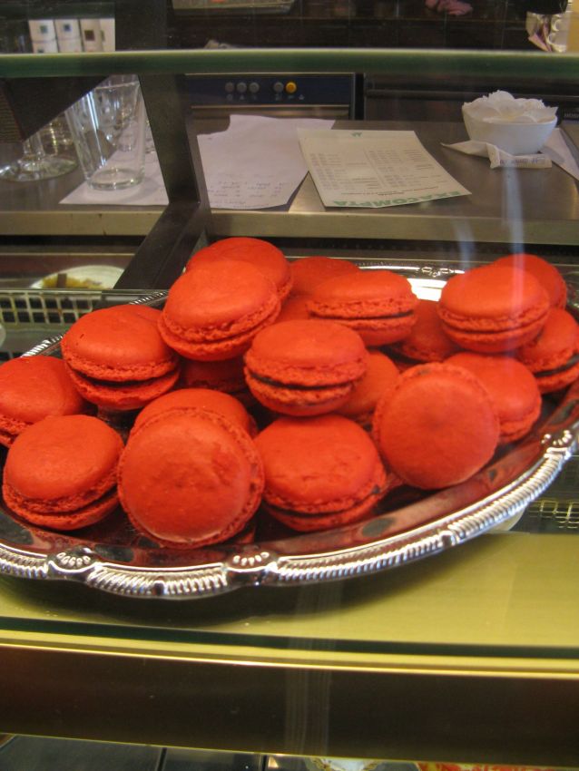 Macarons rossi su vassoio d'argento. Dolci francesi colorati, pasticceria artigianale.