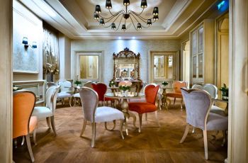 Interni lussuosi: sala da pranzo con lampadario, specchio decorativo e sedie colorate. Design elegante.