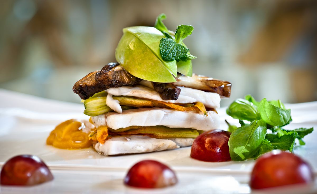 Piatto gourmet: pesce, verdure, mela verde e funghi. Cucina raffinata, ristorante Rubacuori del Chateau Monfort.