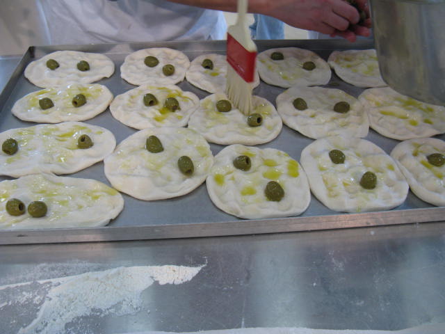 Pizza bianca napoletana con olive. Preparazione della focaccia, olio d'oliva e ingredienti freschi. Cucina tradizionale.