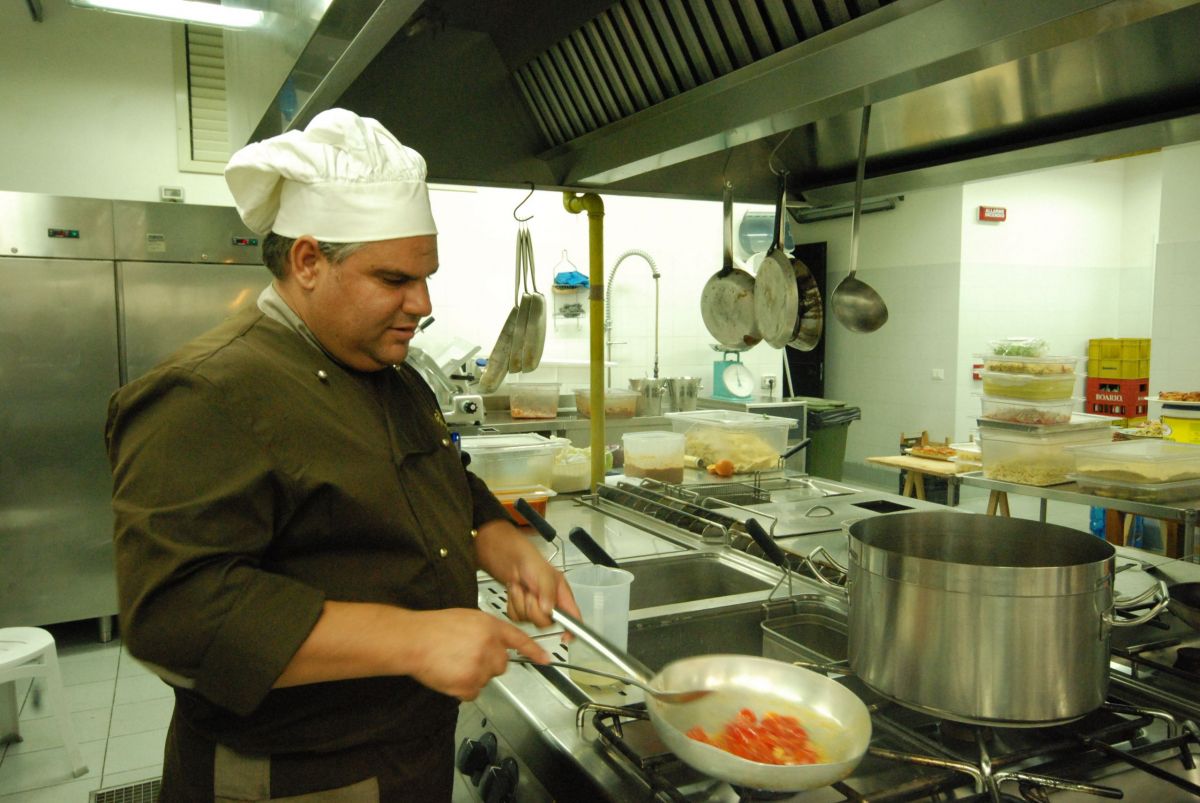 Chef cucina pomodori in padella. Cucina professionale, ristorante, hotel Mahara.