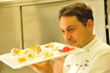 Chef Daniele Repetti con piatto gourmet. Cucina raffinata, ristorante Nido del Picchio a Carpaneto Piacentino.