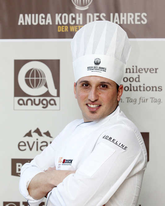 Chef Salvatore Bella, vincitore Anuga Koch des Jahres. Ritratto sorridente in divisa da cuoco.